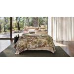 A bed sits in front of a large window with a green rug underneath. Outside is a tree-lined Australian landscape.