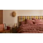 A bed with a geometric patterned fabric bed head.
