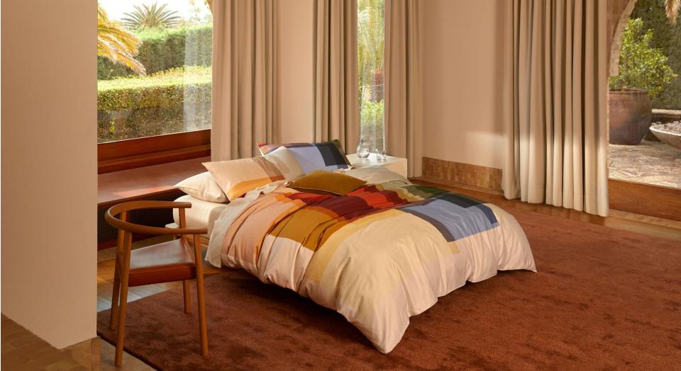 A bed with colourful bedding