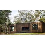 A modern timber house in a rural area, surrounded by gum trees