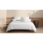 A white striped bed sitting in a neutral bedroom