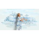 A woman stands, smiling in front of a painterly background. His shirt and pants are in the same matching artwork.