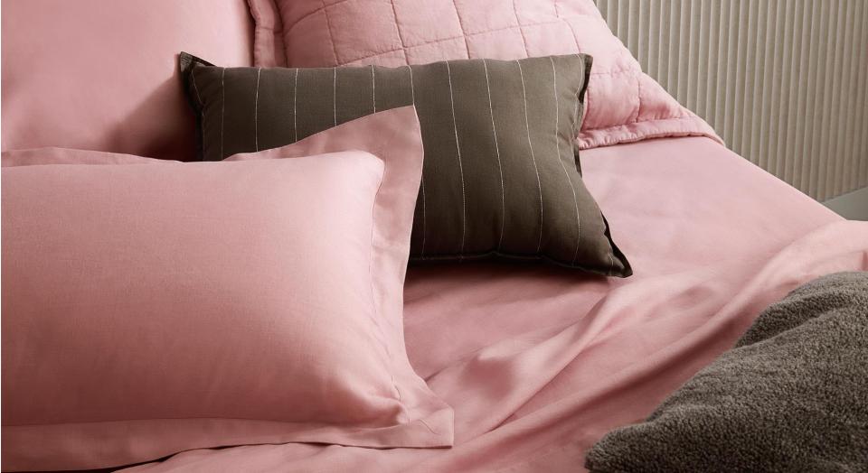 close up shot of pink linen bed with khaki striped linen decorate