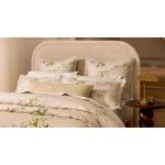 A close-up of a bed with floral sheets and pillowcases