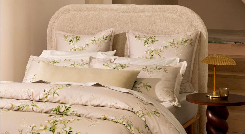 A close-up of a bed with floral sheets and pillowcases