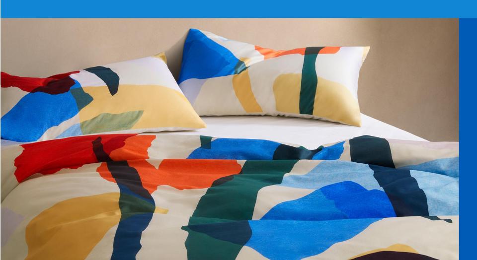 What is dopamine decorating. multi coloured bed with abstract design, bordered on two sides by different shades of blue.