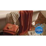 Aven bath towels in relish and limestone stripe draped over the side of a bath tub