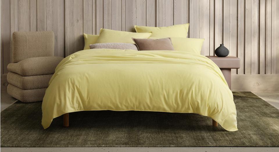 A yellow bed sitting in a neutral bedroom