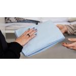 A close-up of two pairs of hands passing a SleepSafe sleep kit between them