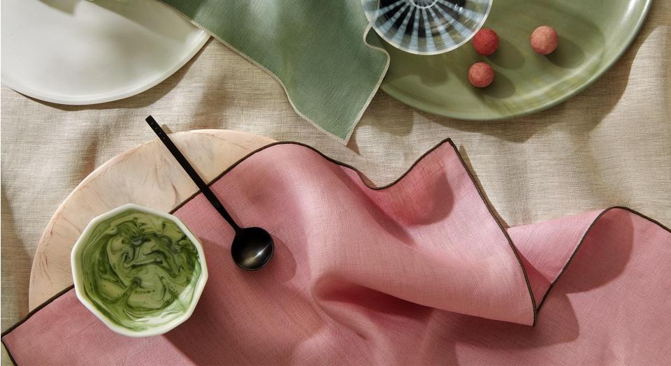 overhead shot of abbotson table linen dinner set up. pink and green napkins.