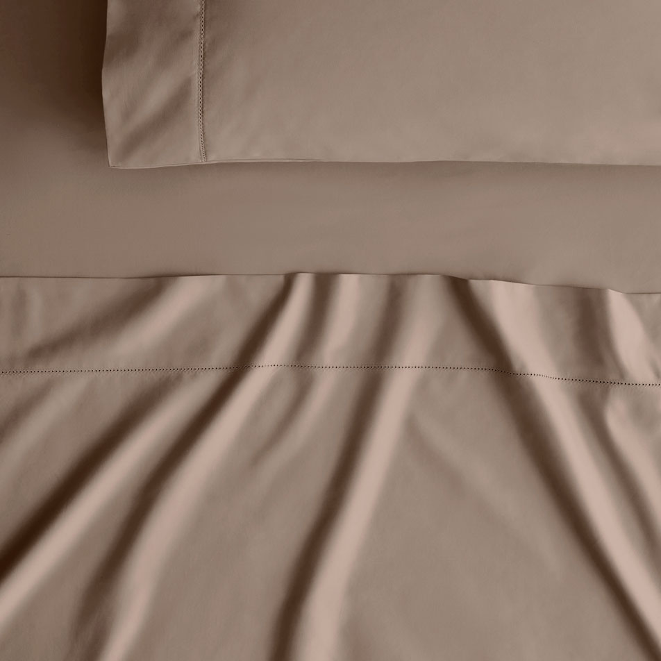 Close up photo of a Hotel Luxury sheet set in mocha. A matching pillow sits on top.