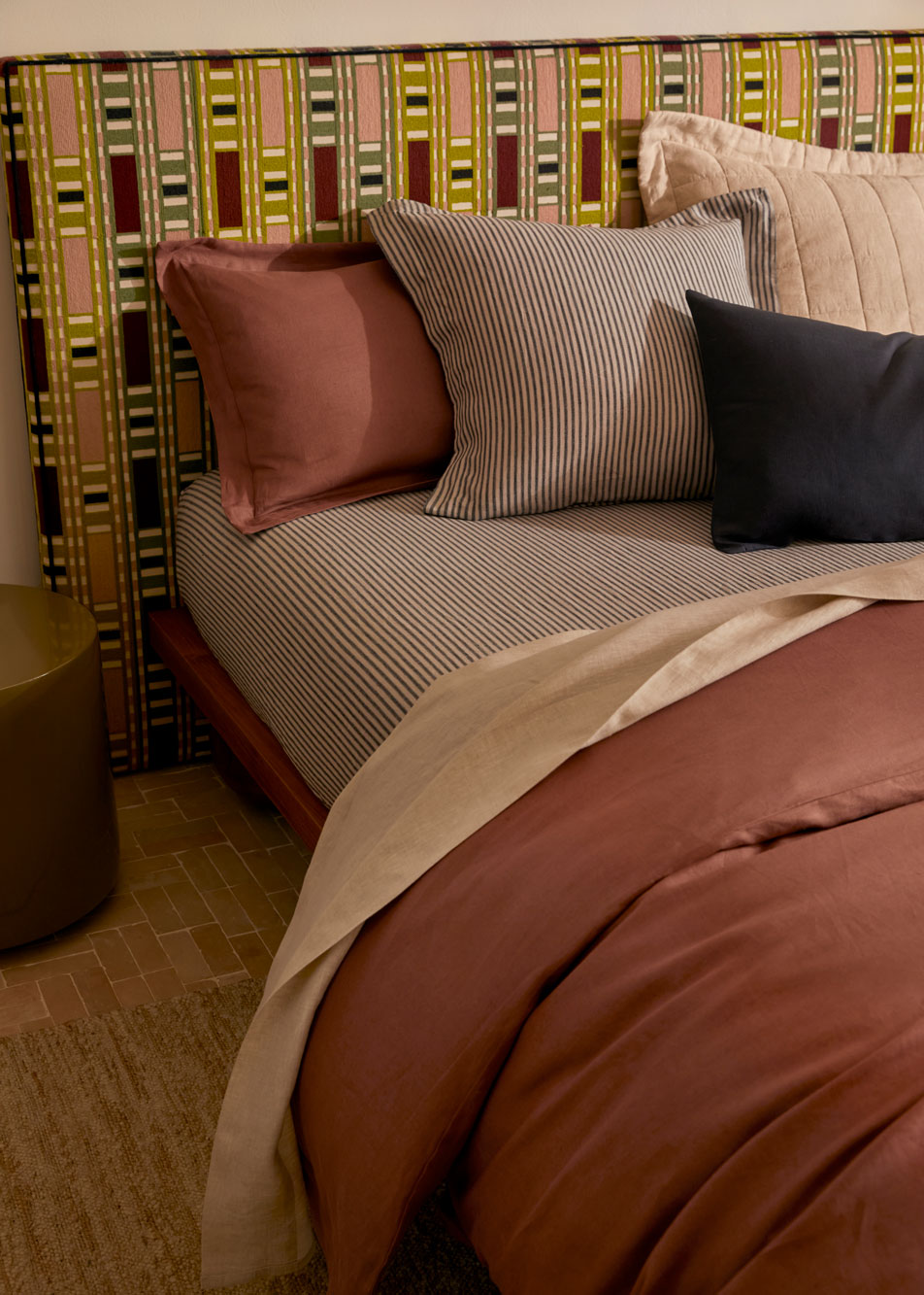 A bed made up in different colours of Abbotson Linen