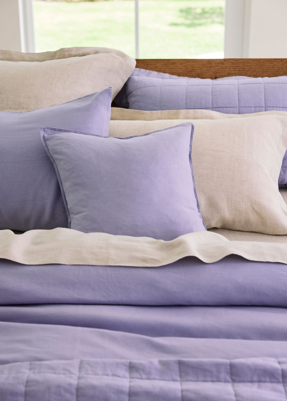 A close-up of layers of pillows and cushions sitting on top of a bed