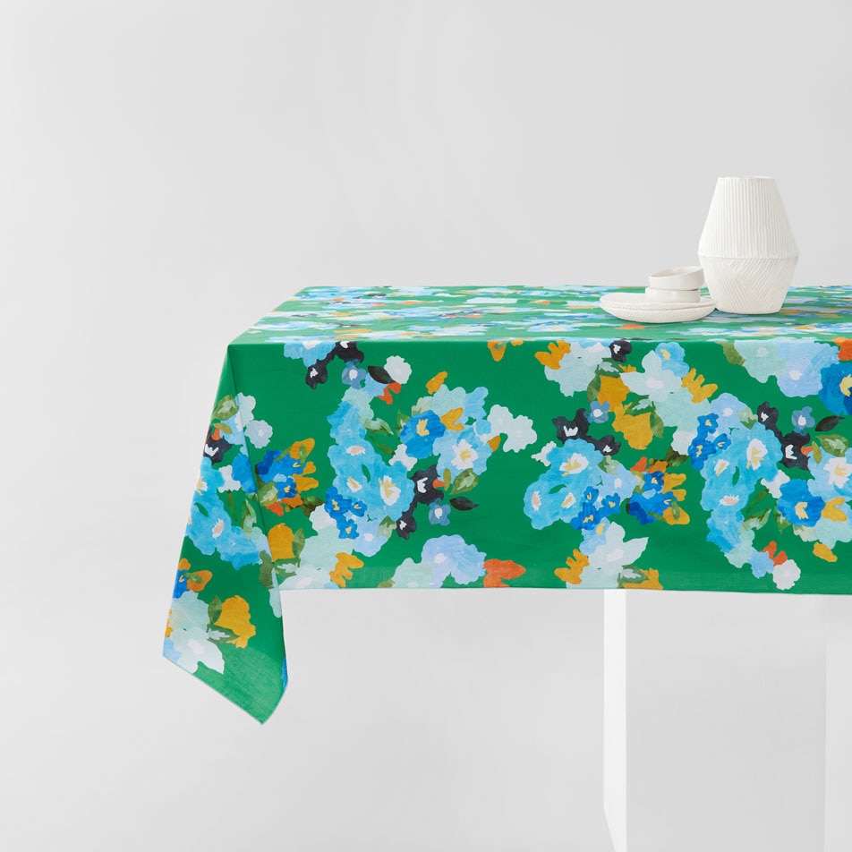 Sheridan Aya tablecloth on a dining table with a white vase and plate on top