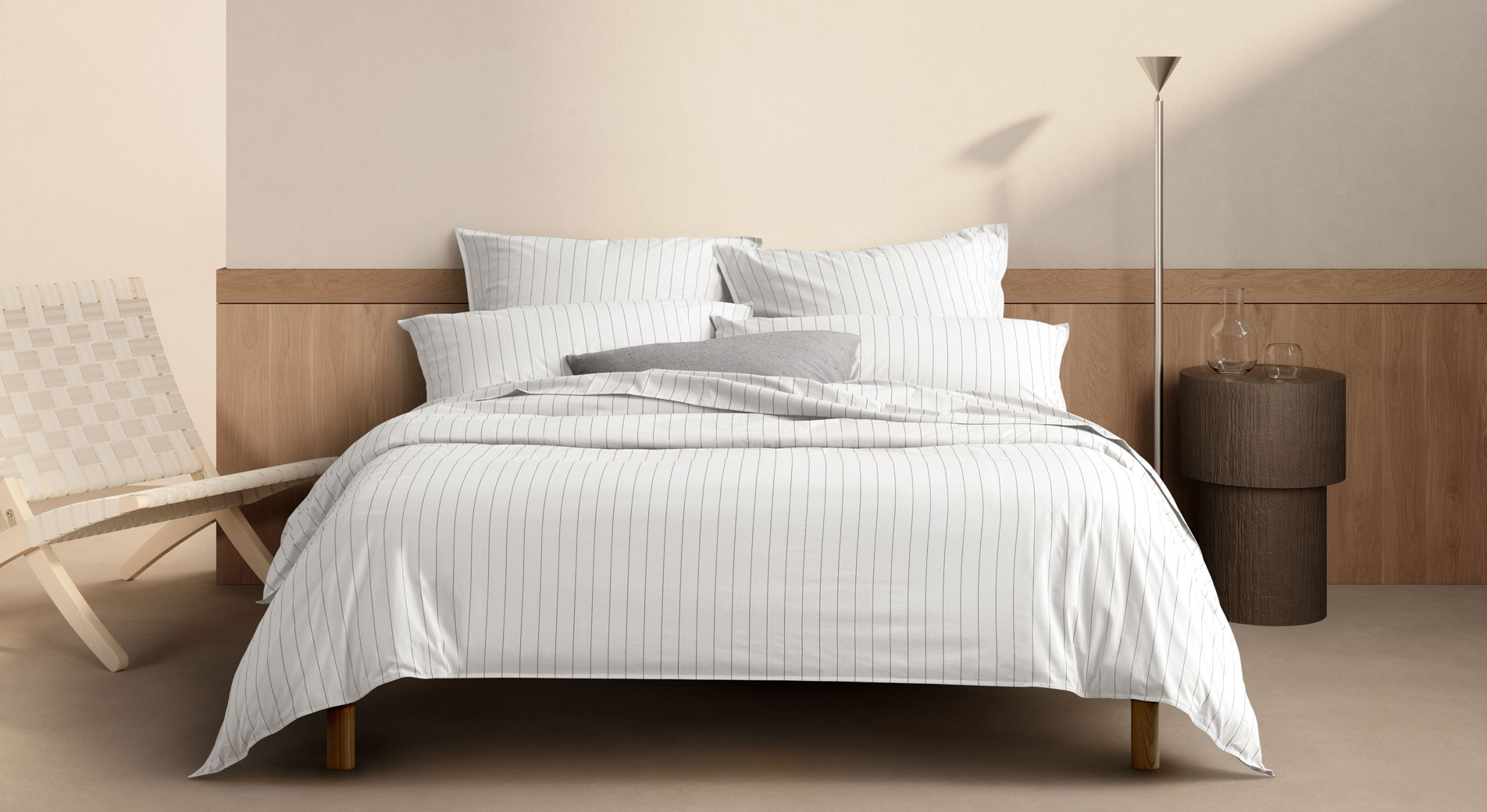 A white striped bed sitting in a neutral bedroom