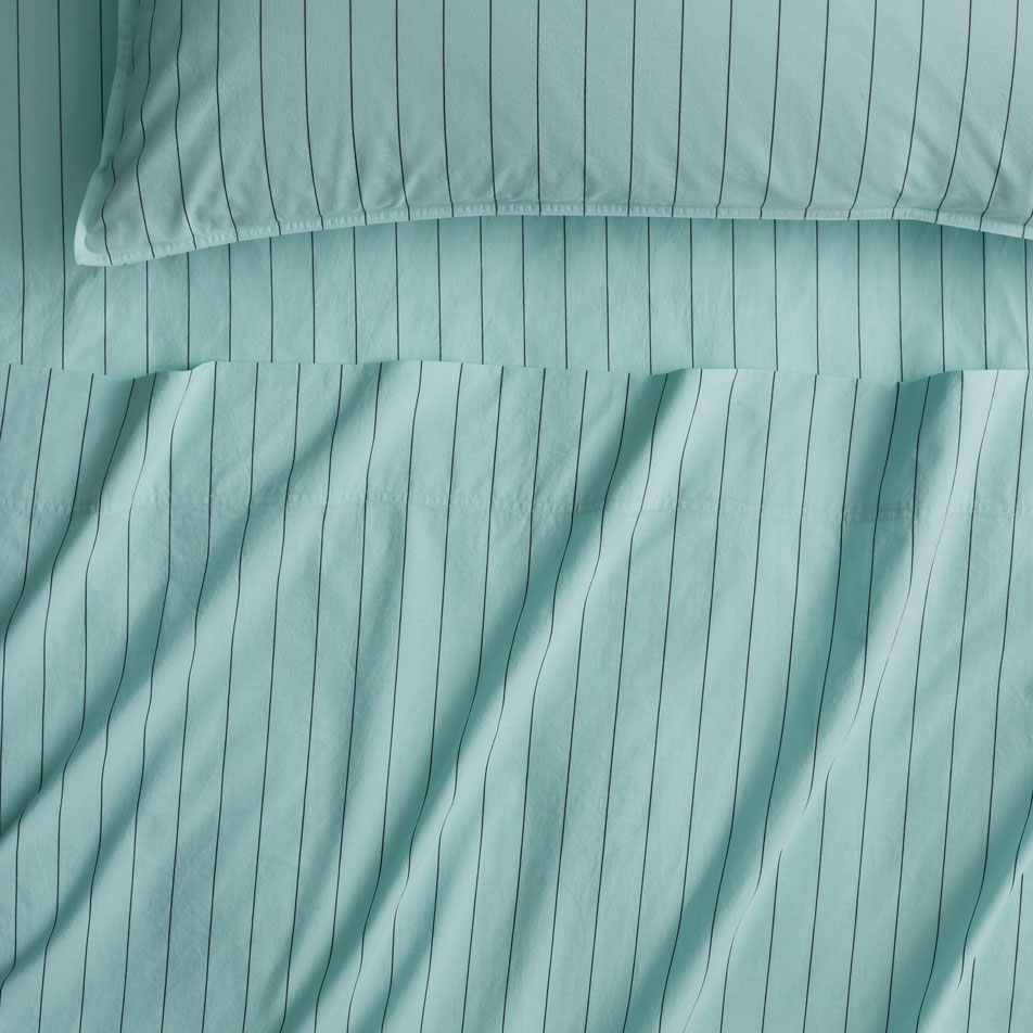 A close-up of blue stripe cotton percale sheets.