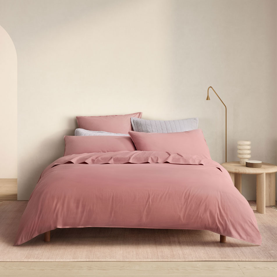 A bed dressed in Bayley Washed Percale bedding in the colour rose