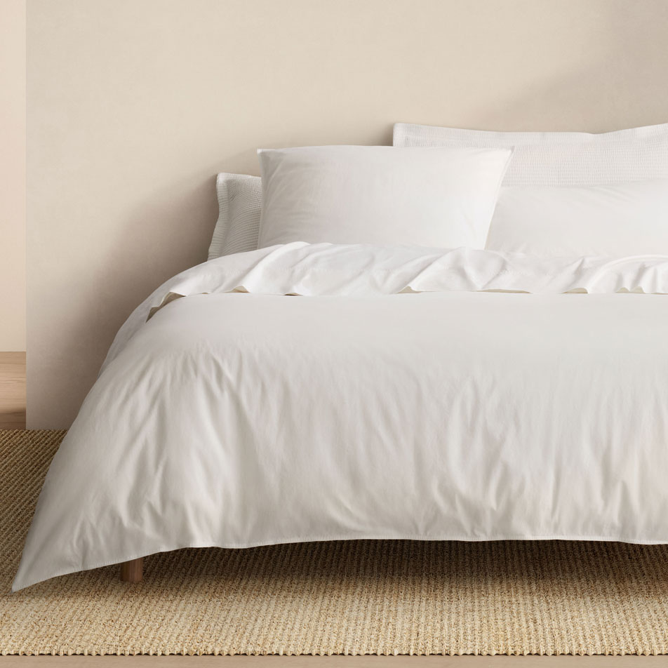 A bed dressed in Bayley Washed Percale bedding in the colour white