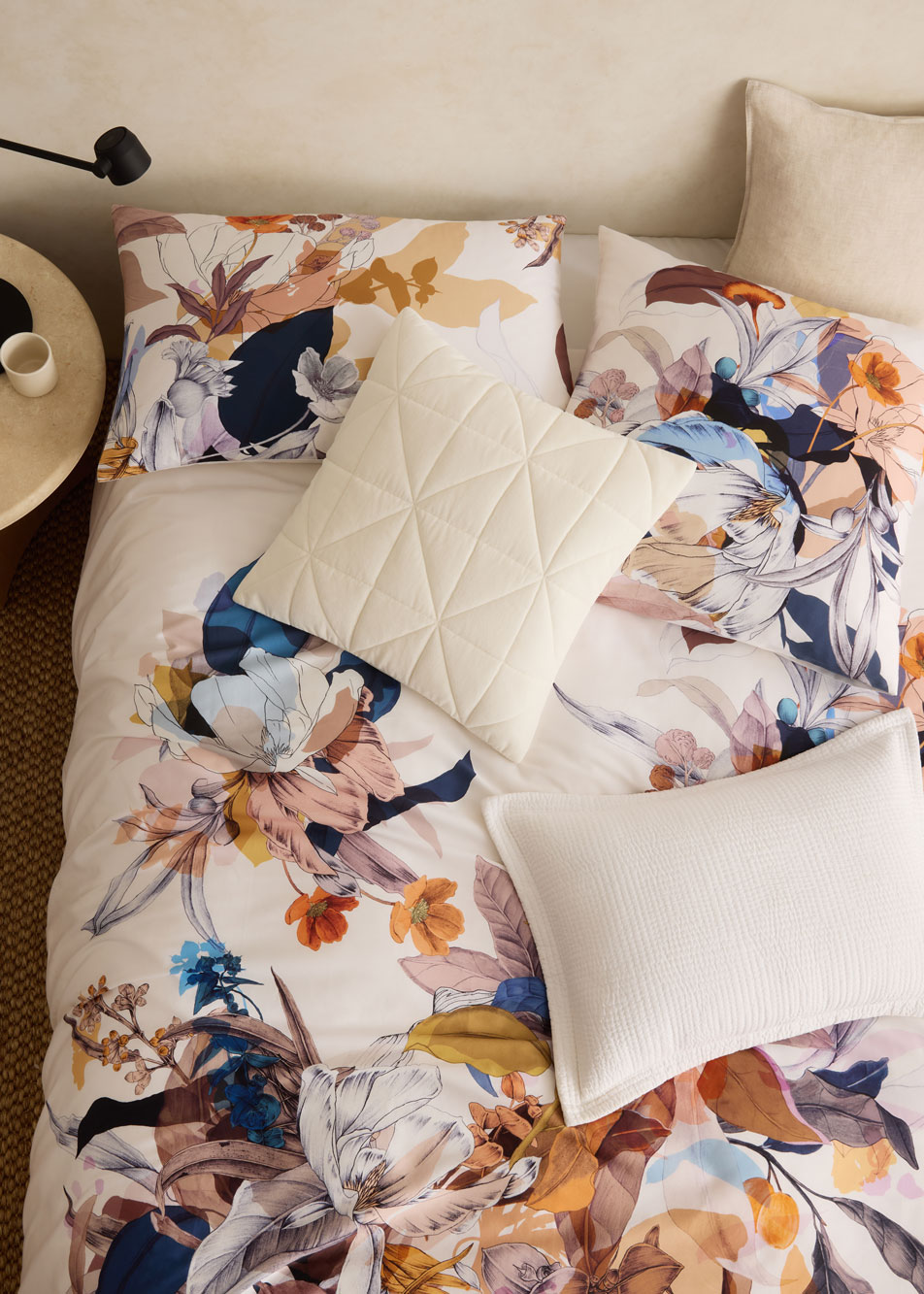 A floral print bed with white cushions