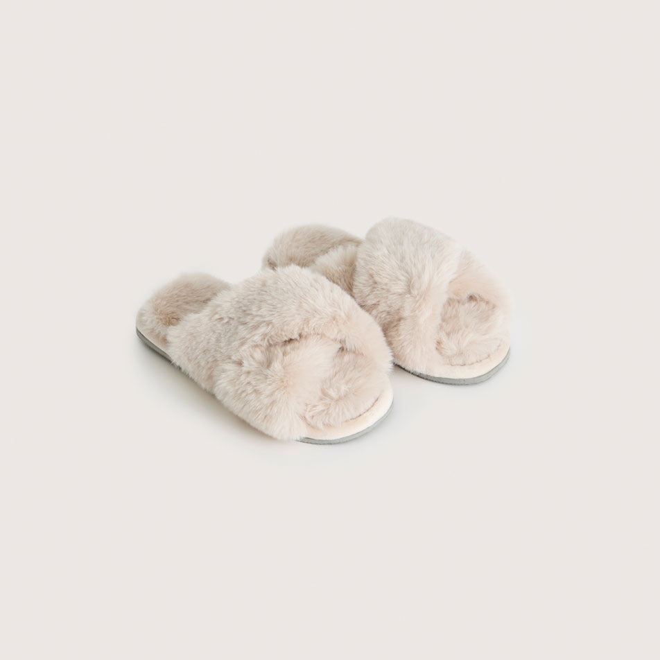 A pair of Carlson faux fur slippers in the colour bone