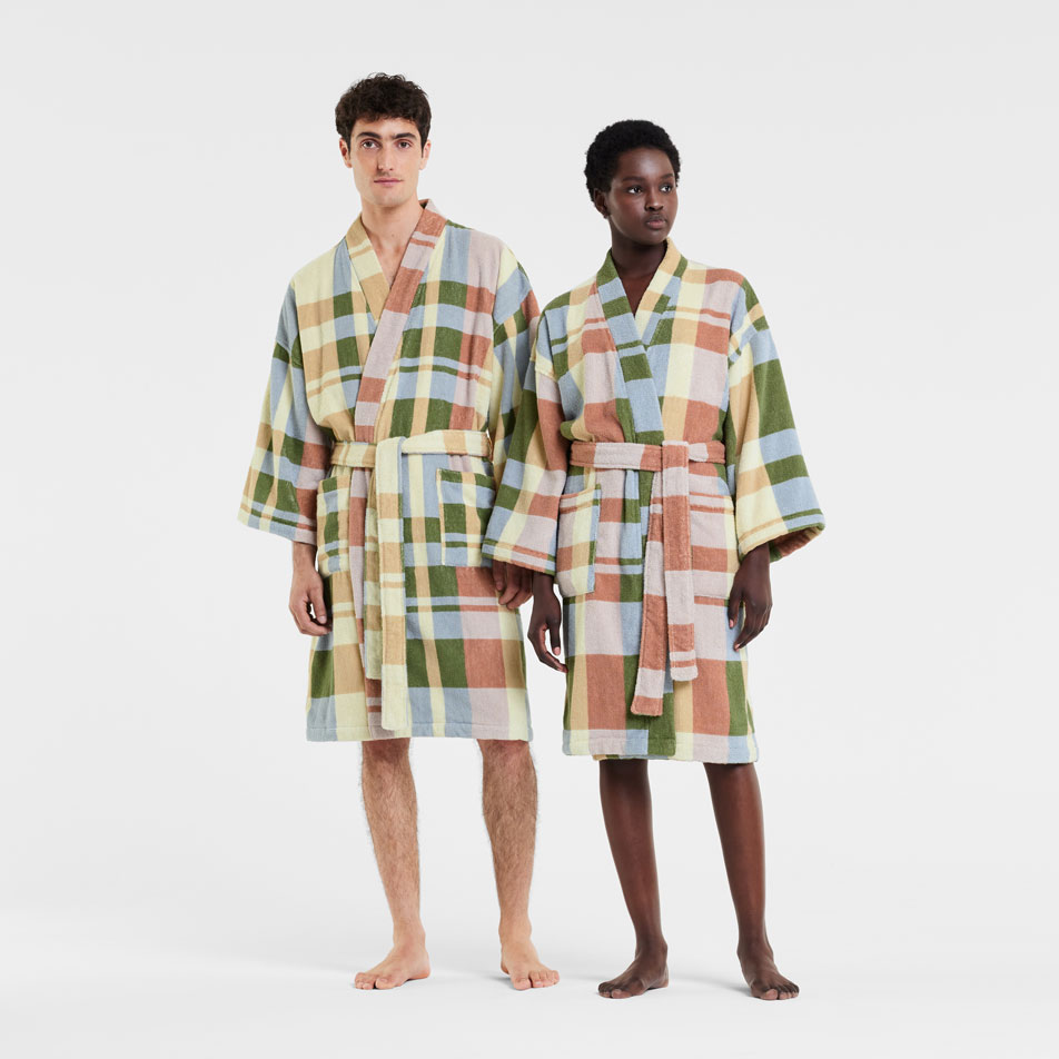 Two models wearing colourful check robes standing in front of a white backdrop