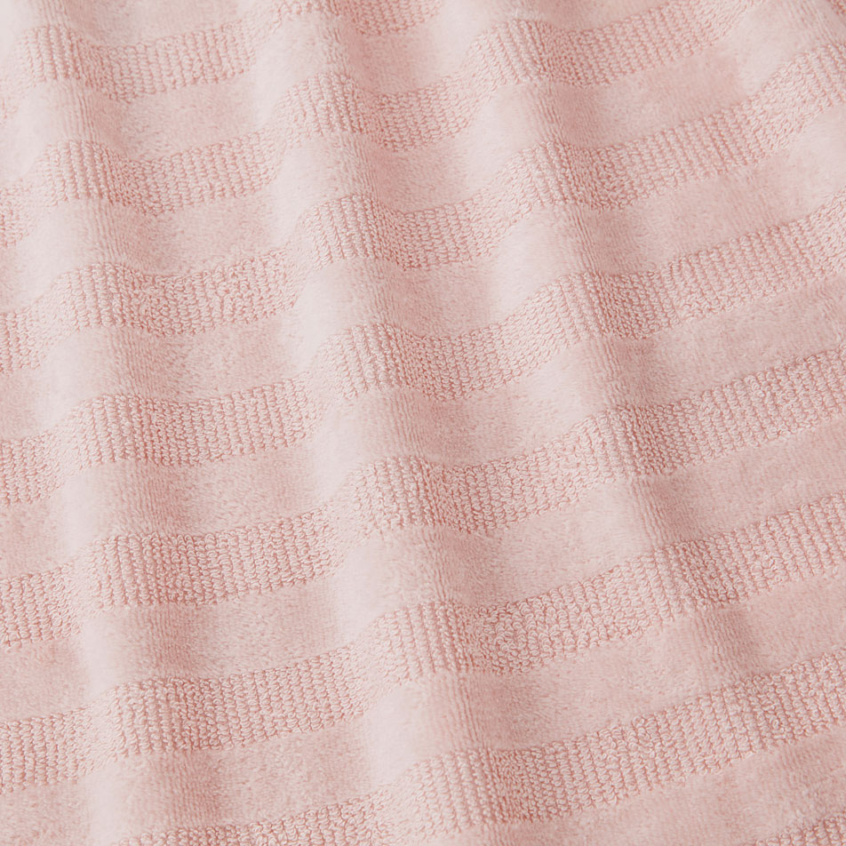 A close up image of light pink terry fabric, with textural stripes