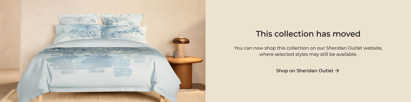 A woman stands, smiling in front of a painterly background. His shirt and pants are in the same matching artwork.