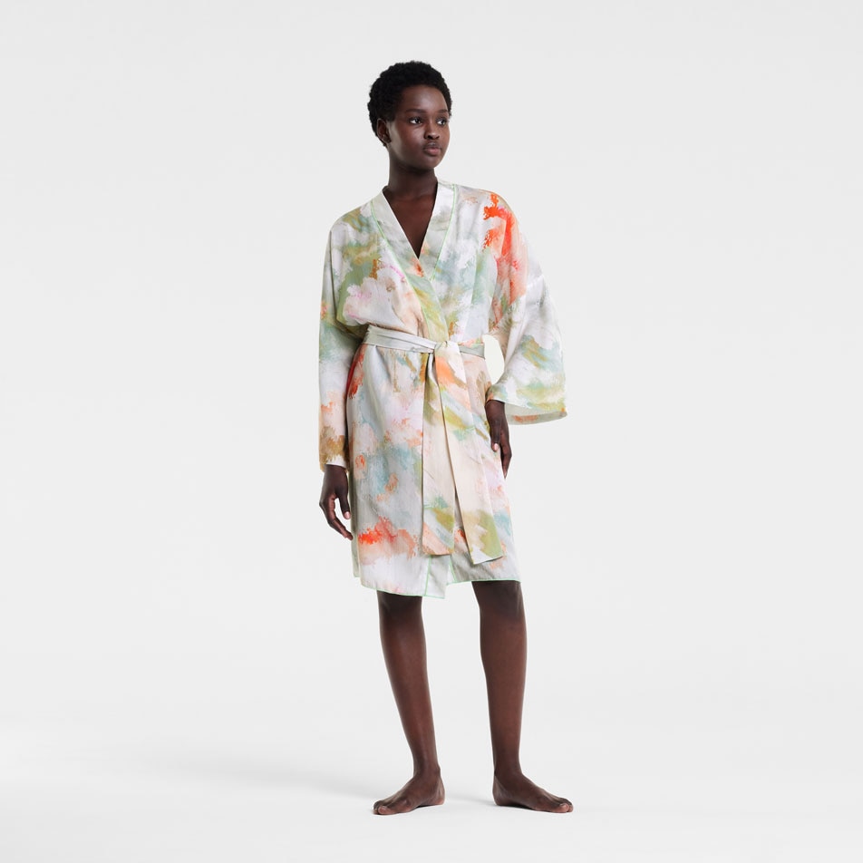 A model wearing a TENCEL bathrobe in front of a white background