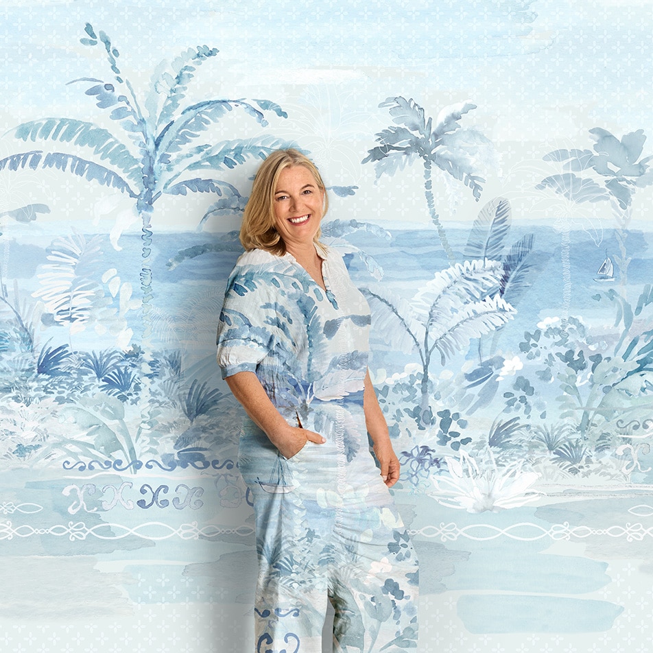 A woman standing in front of a painterly background. Her clothing is the same print as the backdrop.