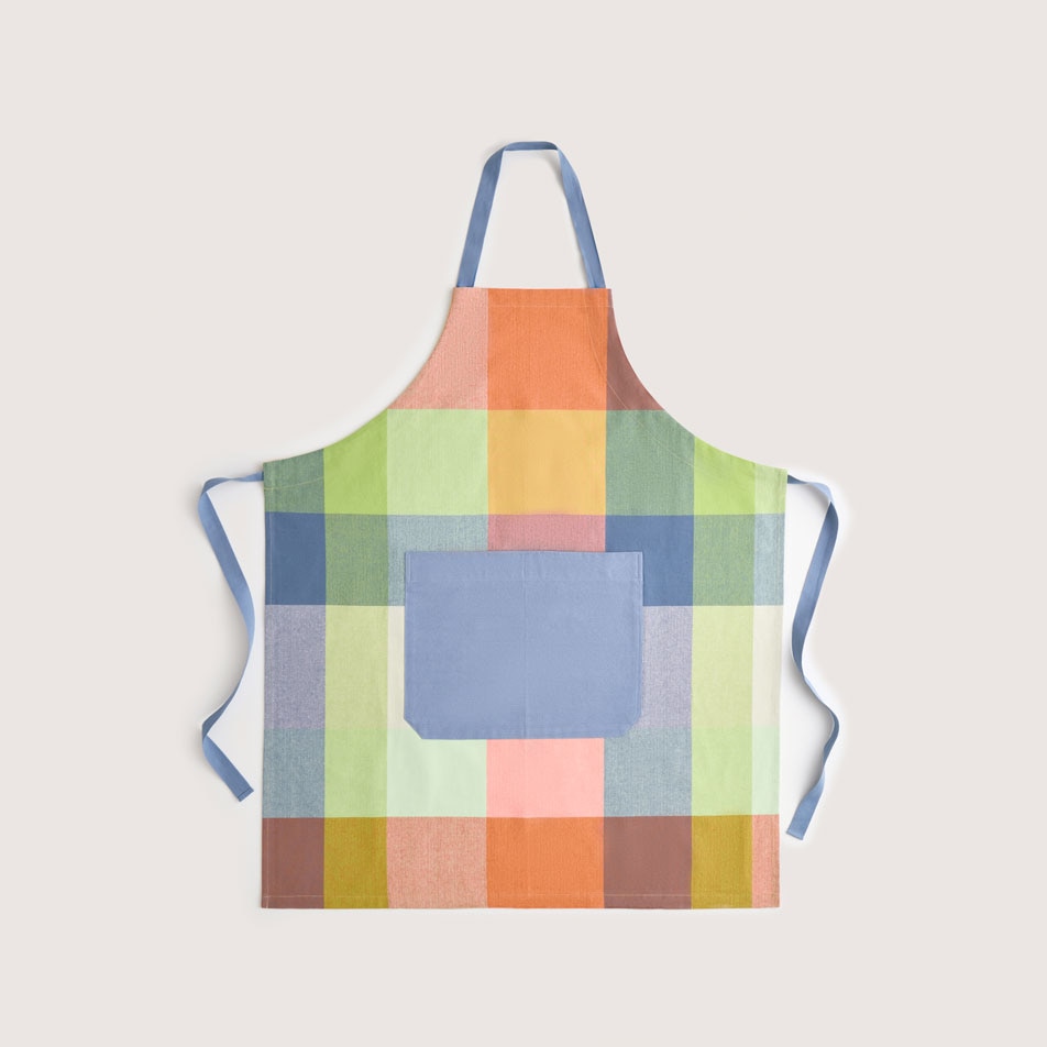 A flay lay image of a Lumo fabric apron in the colour peach