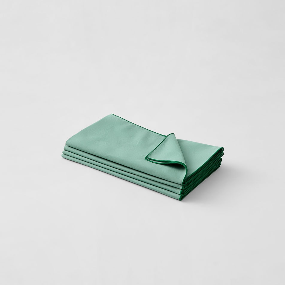 Image of a stack of folded Sheridan Mette napkins in the colour matcha
