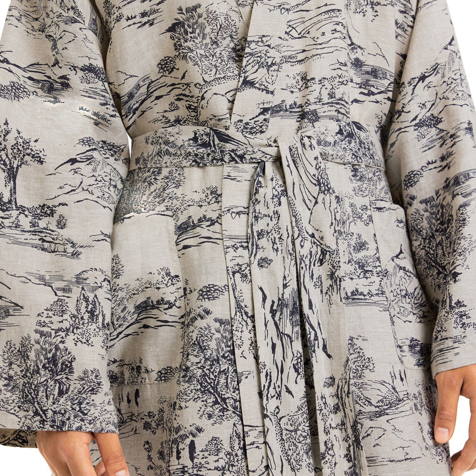 Close up image of a linen robe with a monochromatic landscape print all-over