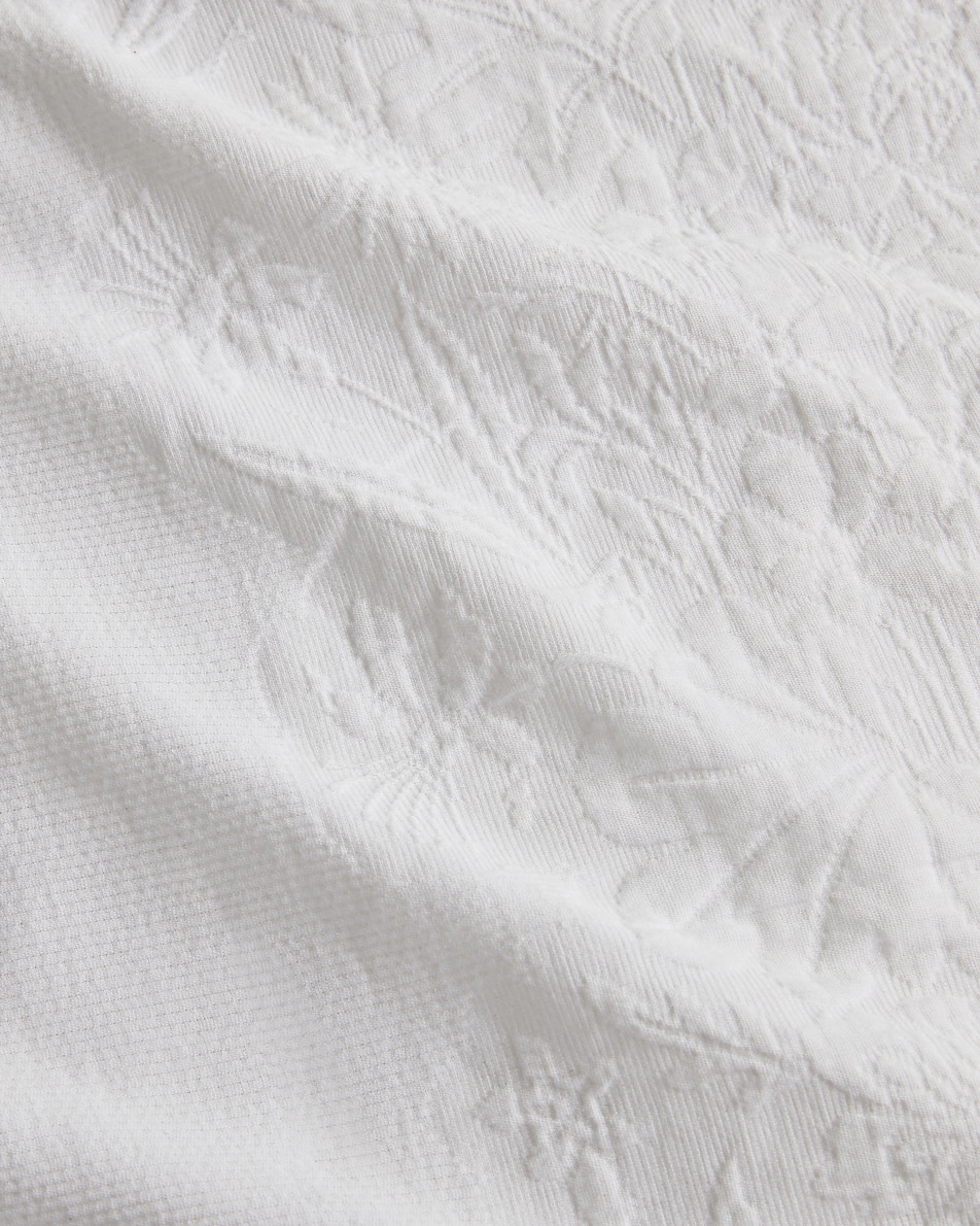 Close-up image of white cotton matelasse fabric
