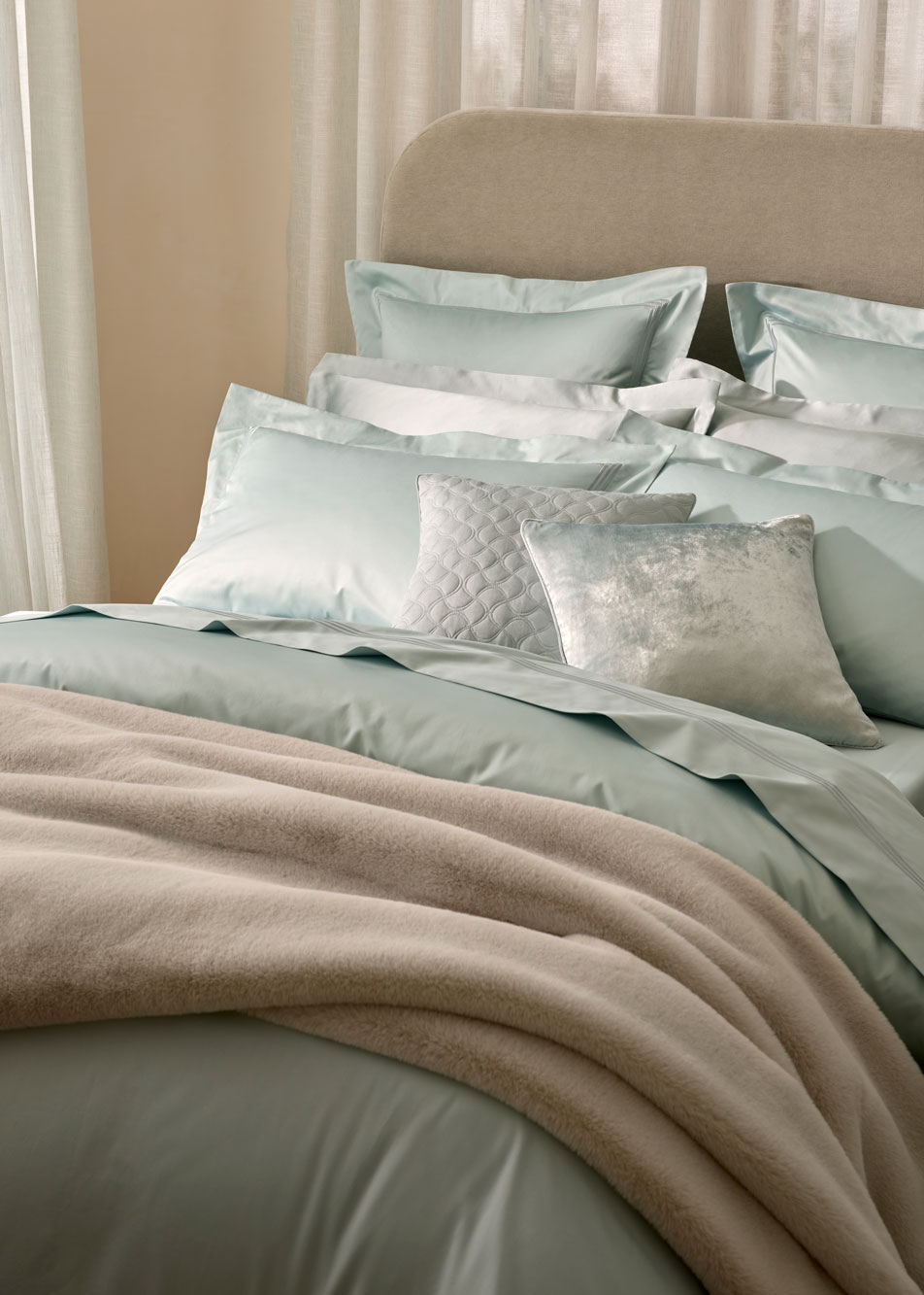 A bed dressed in Palais Lux bed linen in the shade fresh water