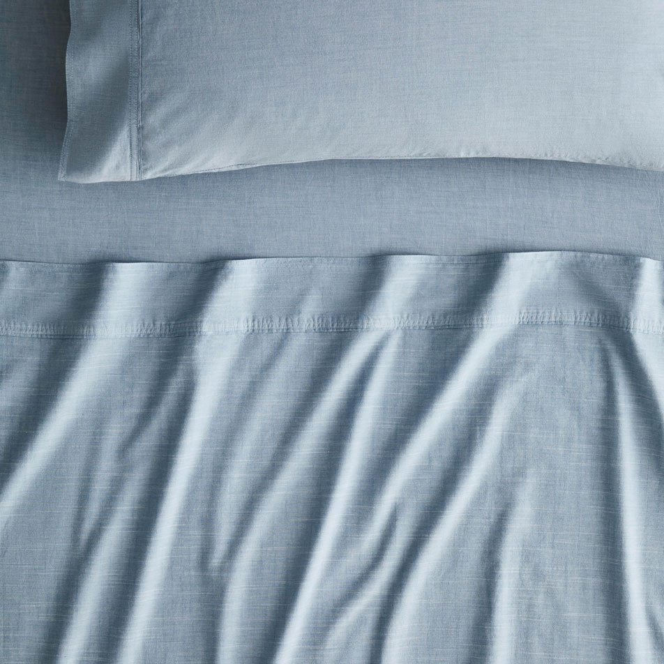 Close-up of a bed dressed in Reilly chambray sheets