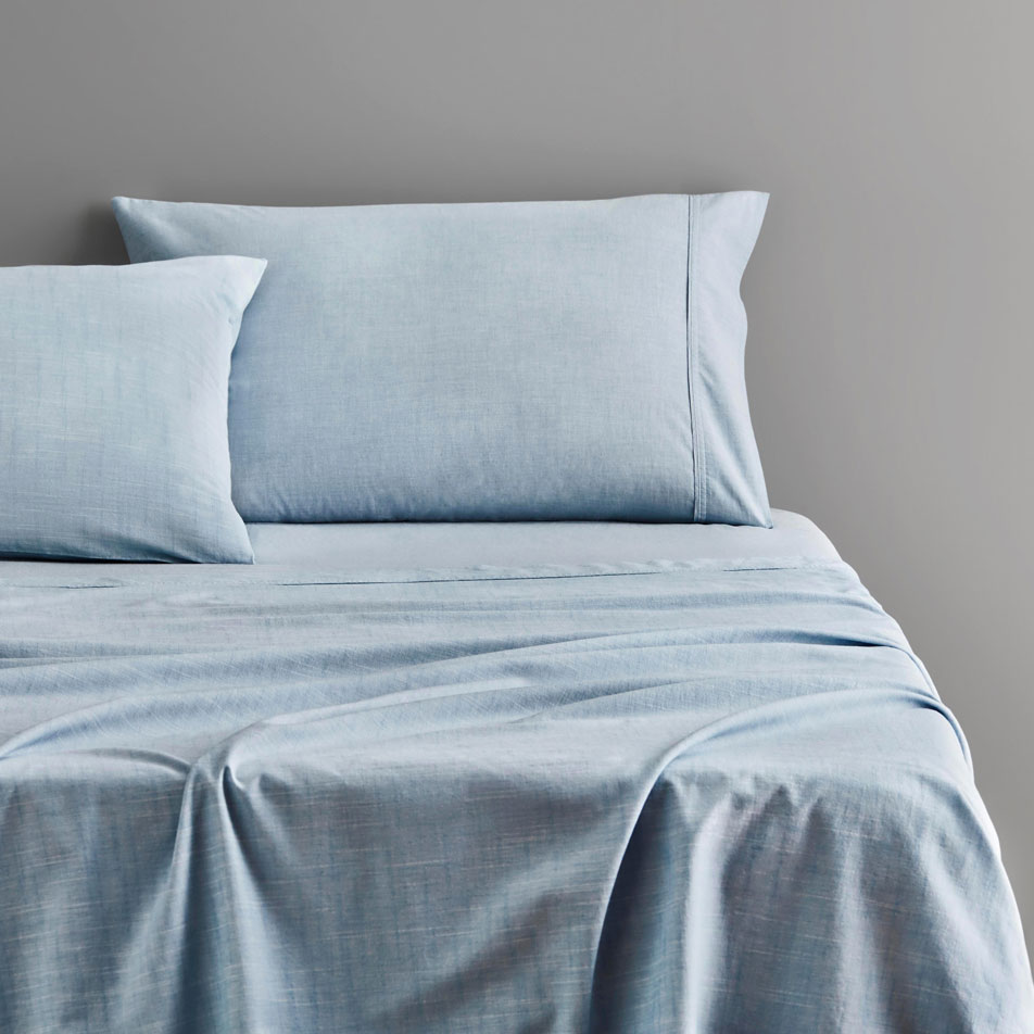 Close-up of a bed dressed in Reilly chambray sheets