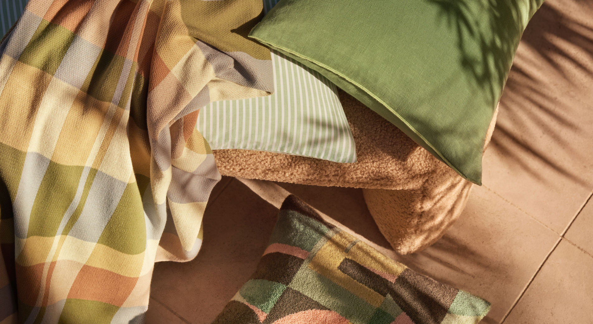 Cushions and a throw scattered over a chair and onto the floor