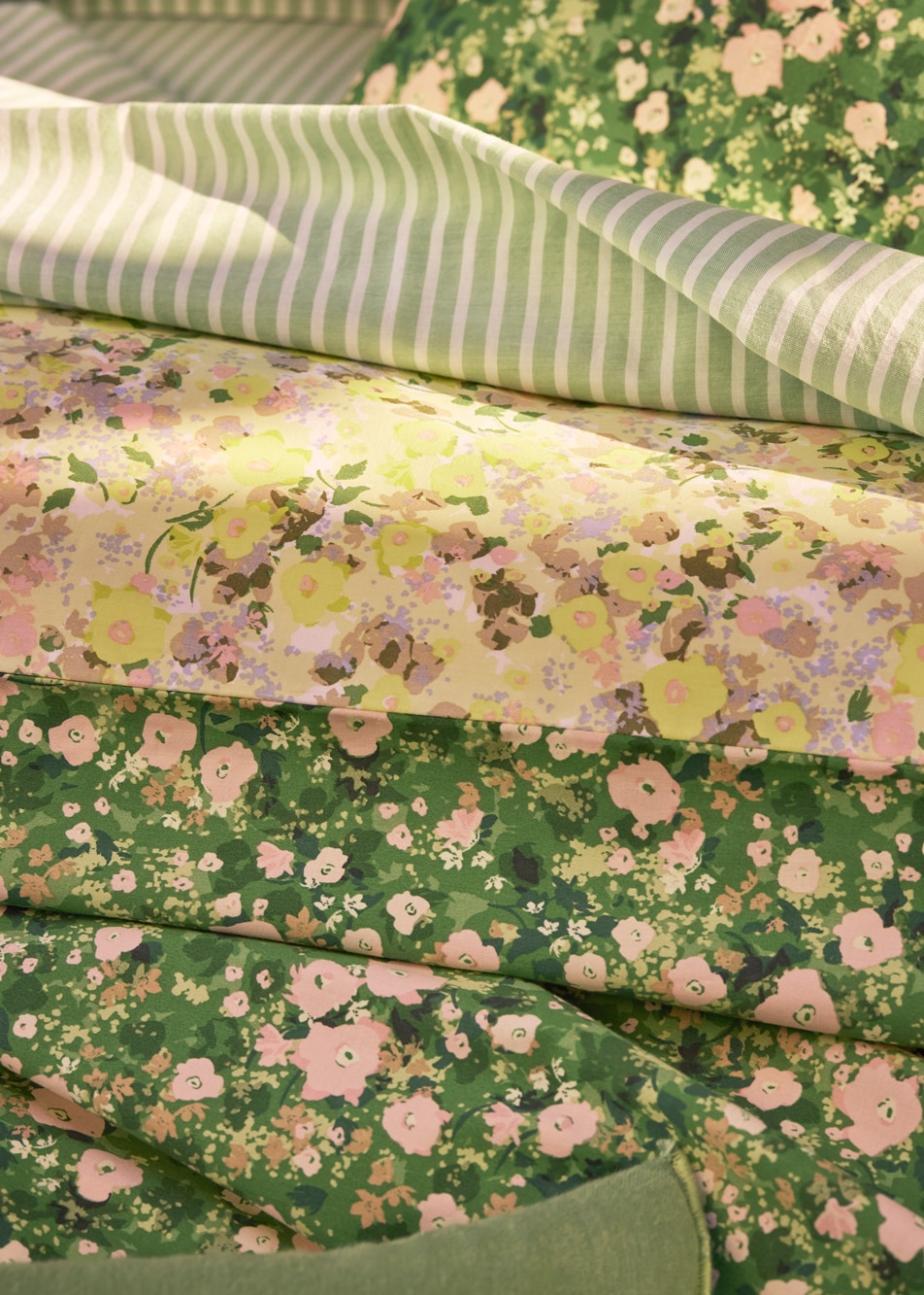 A close up image of layered sheets with floral and stripe prints