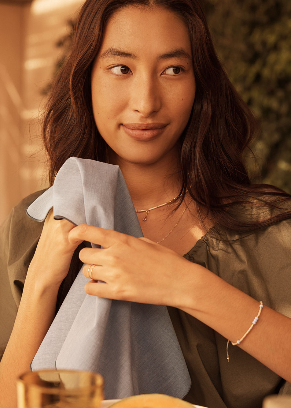 A young woman holding a fabric napkin