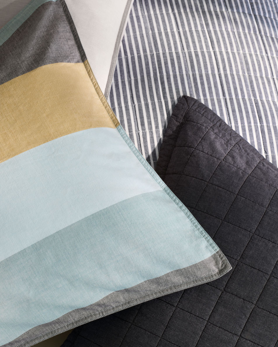 A close-up of Reilly pillows in club stripe, classic stripe and plain dye colours