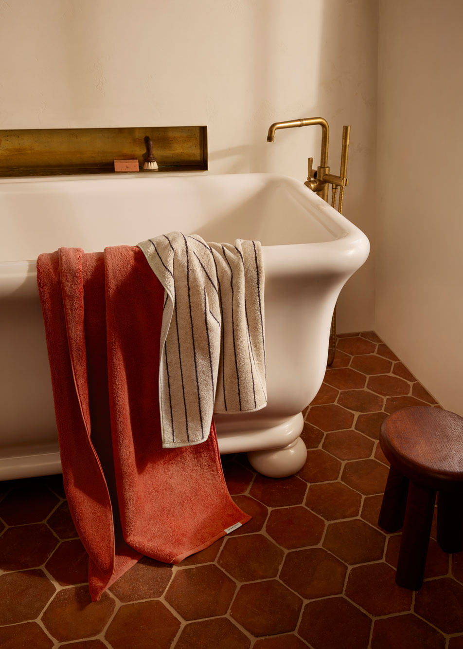 Two towels draped over the side of a porcelain bath tub