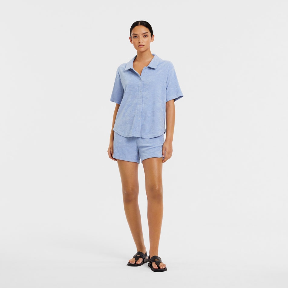 A model wearing the Soraya shirt and shorts set in blue mist