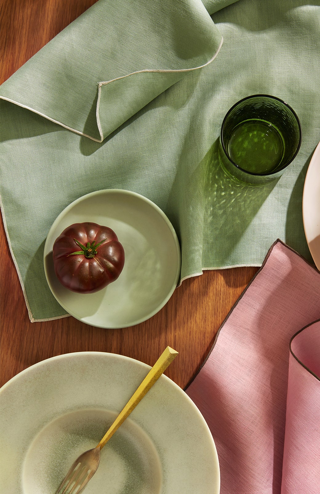 overhead shot of abbotson linen napkins in cherry blossom and cactus. set up for dinner party.