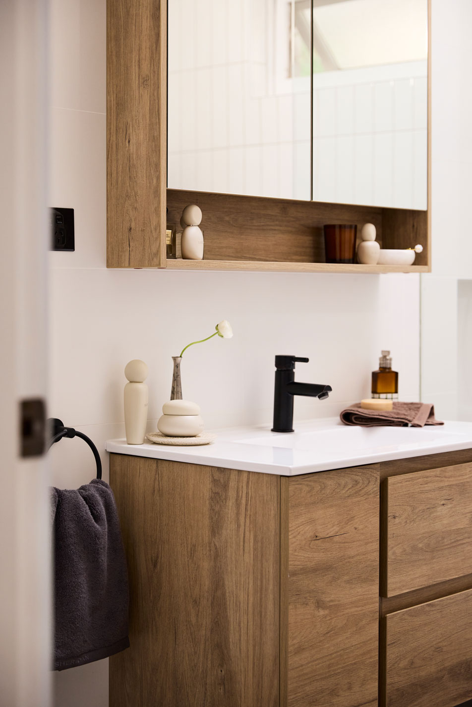 A modern, timber bathroom sink with a white basin.