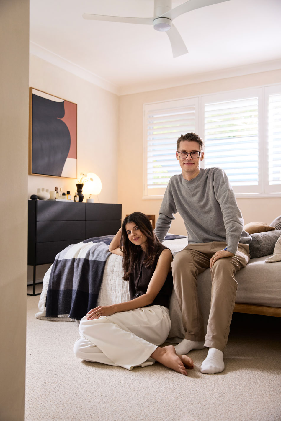 A brunette woman sitting on the edge of a kids' bed