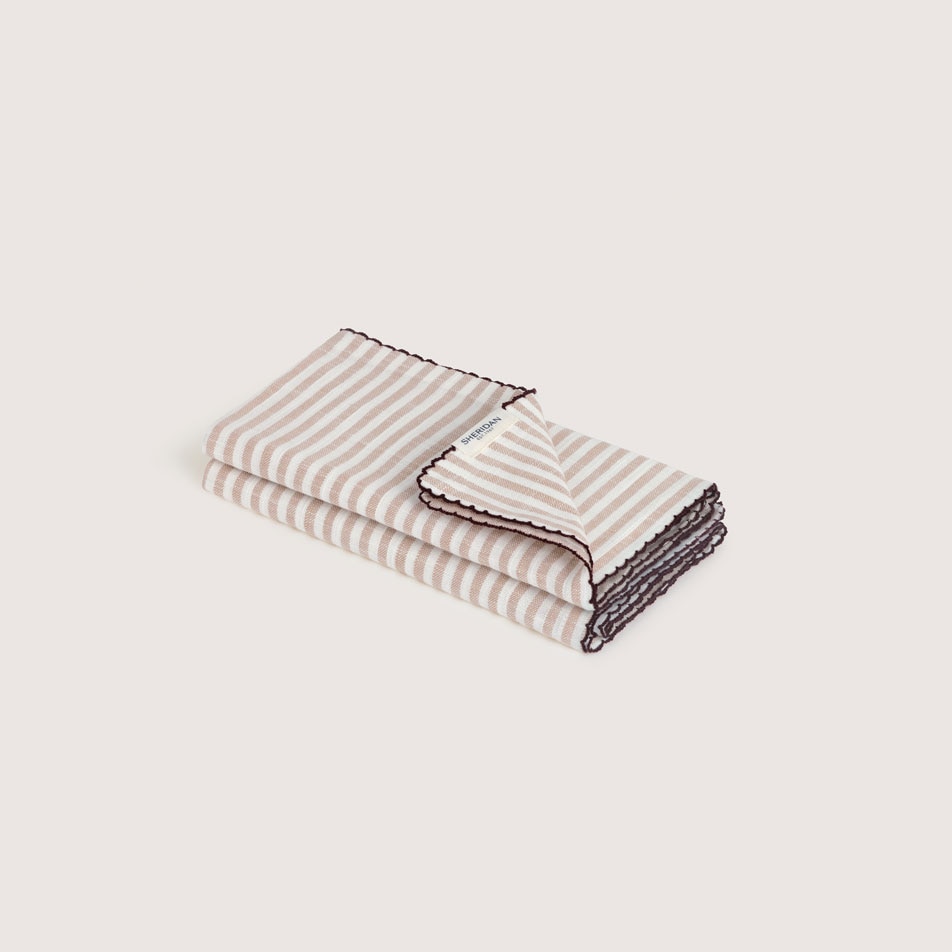 Two folded fabric napkins in the colour dune stripe