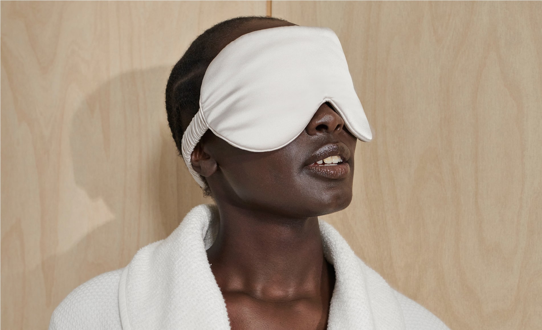 close up black woman braided hair white silk eyemask over eyes