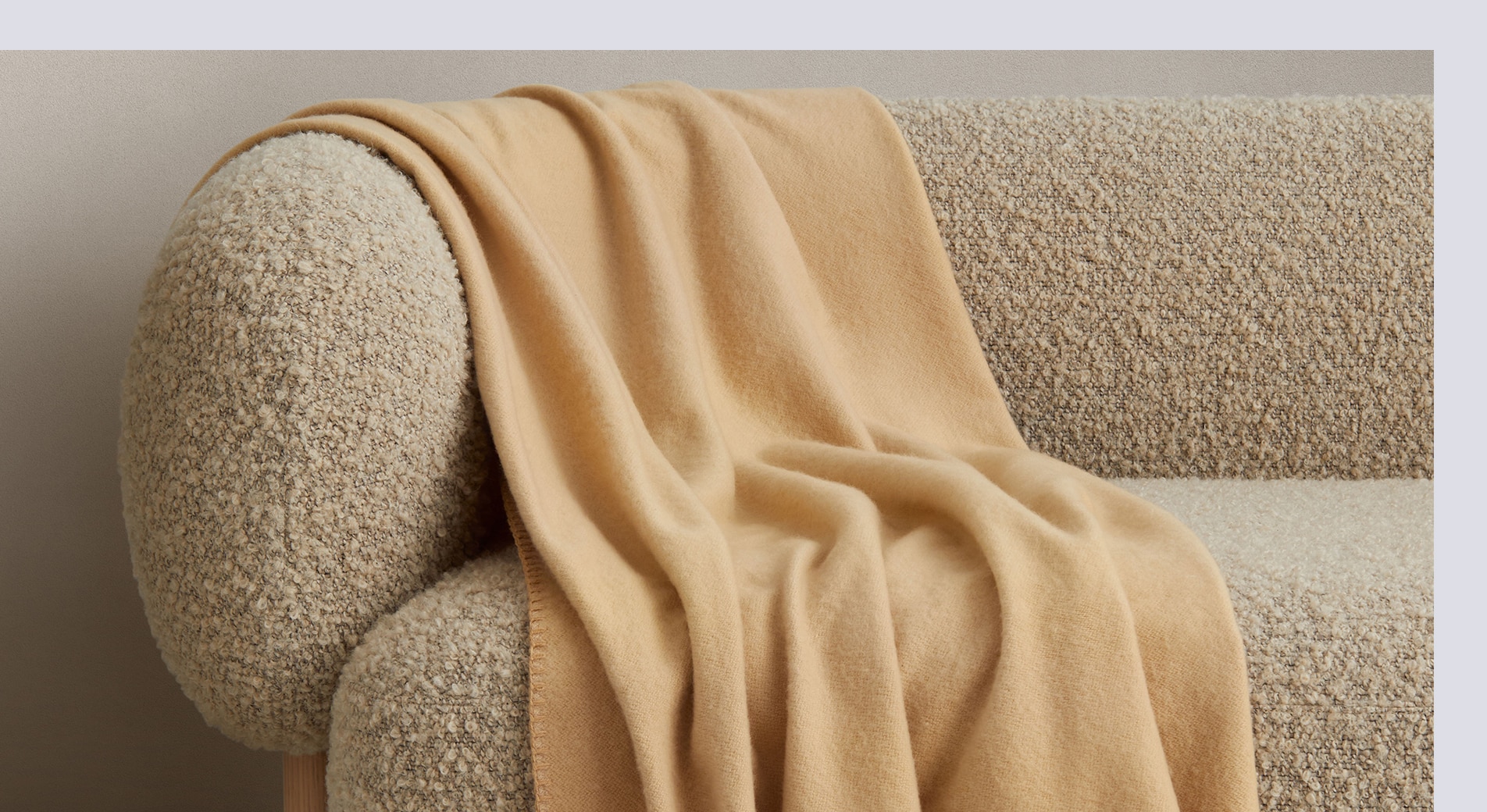 how to layer a bed for winter. butter coloured wool throw is stylishly thrown on boucle couch.